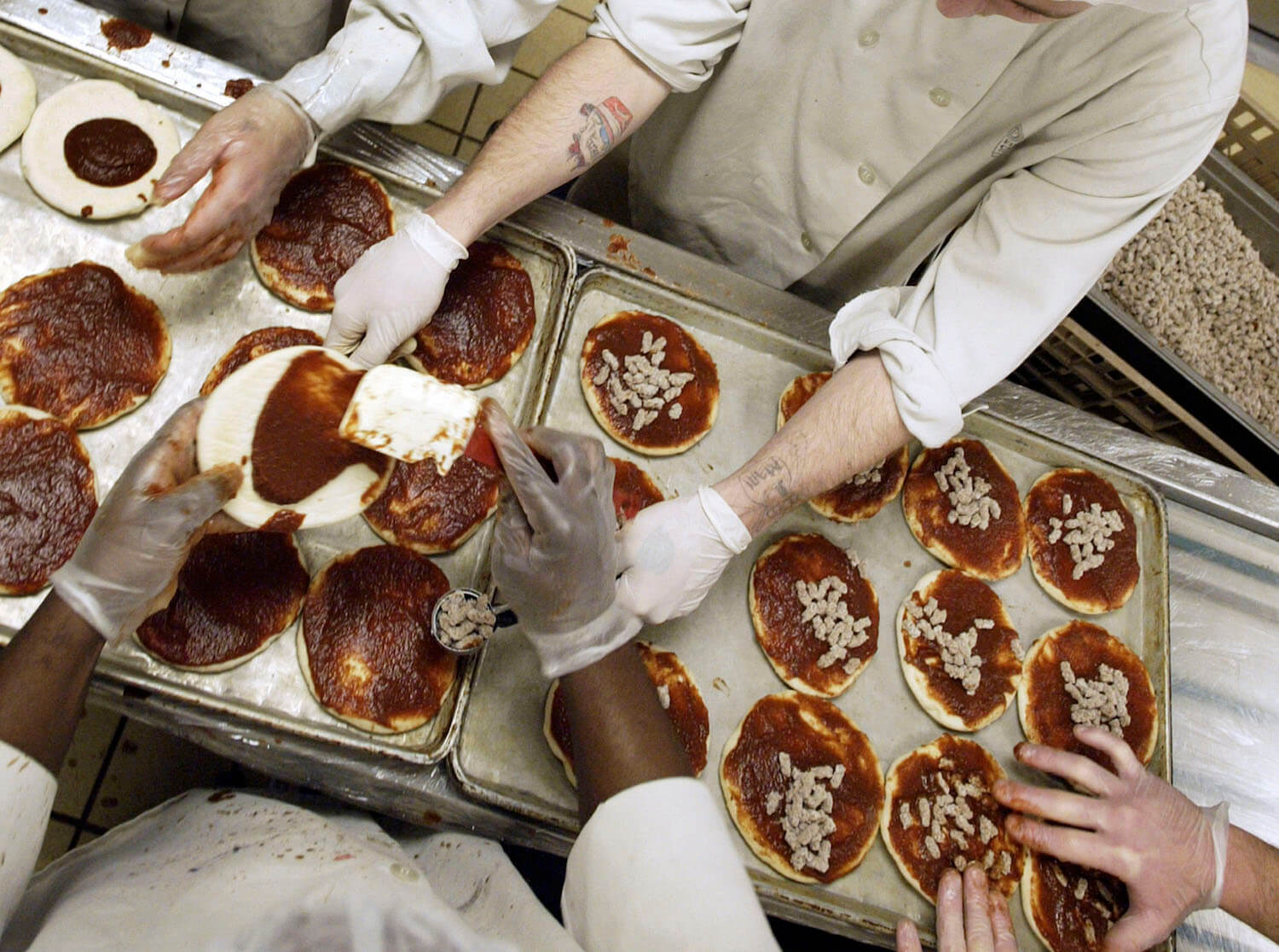 Inmates at the Airway Heights Corrections Center work on a production line to make mini-frozen pizzas at the largest prison-based food factory in the Northwest, November 10, 2005 in Airway Heights, Washington.