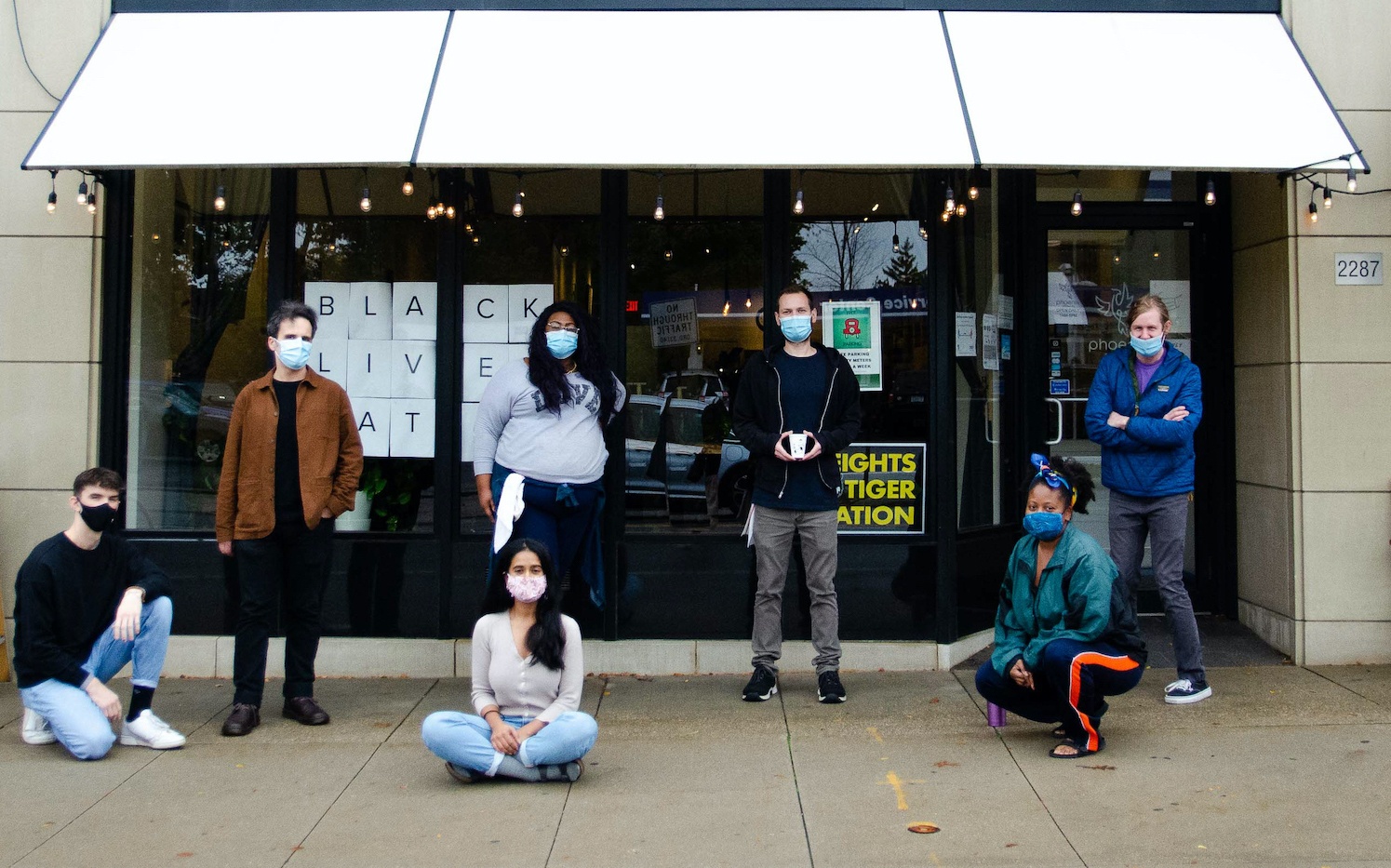 Staff at Phoenix Coffee Company stand in front of the storefront wearing masks and socially distanced. October 2021